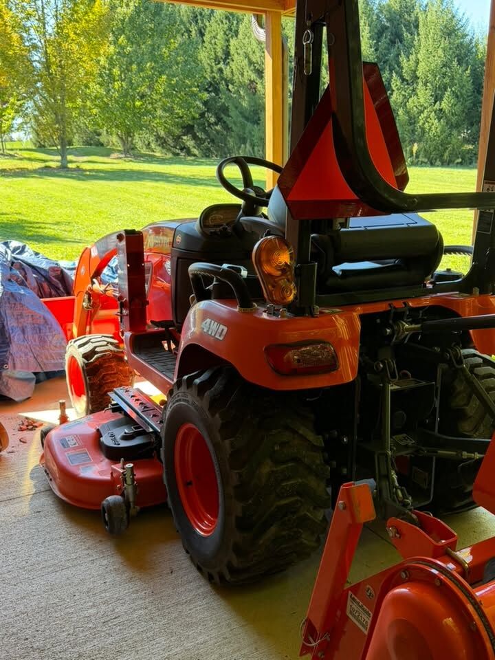 Compact tractor with mower deck on a lawn